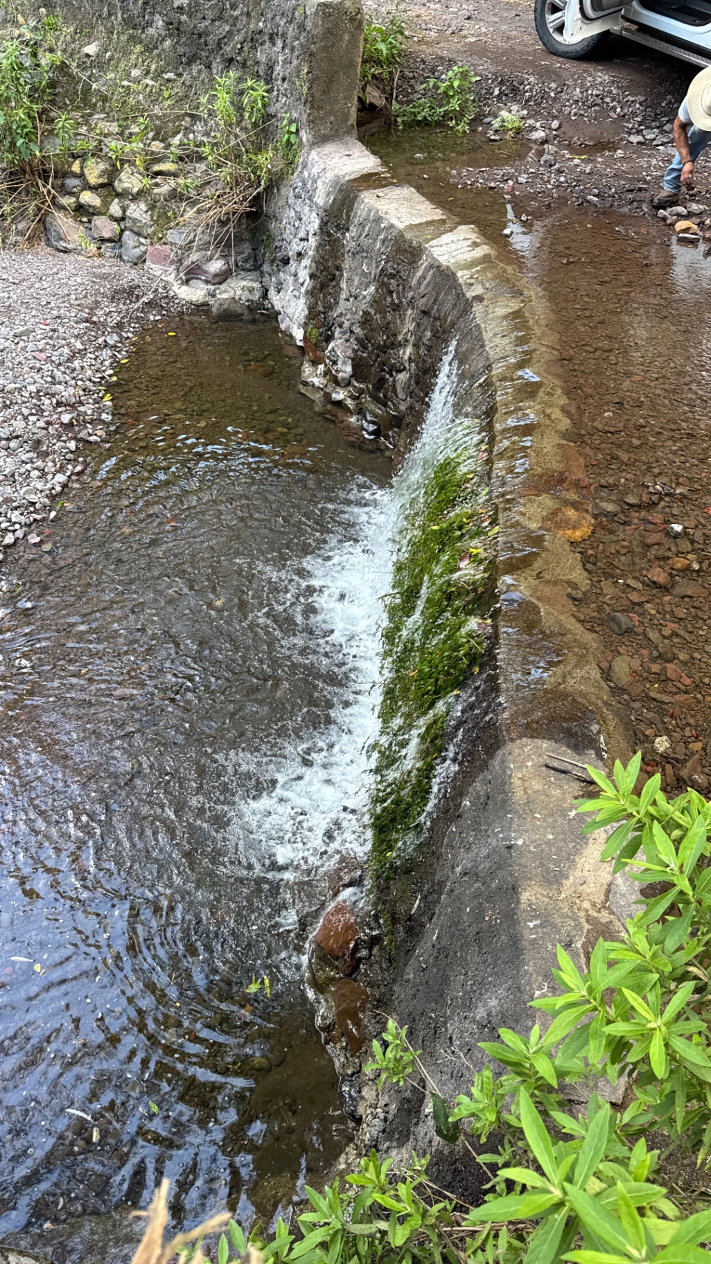 Agua de manantial corriendo sobre una vieja presa de piedra